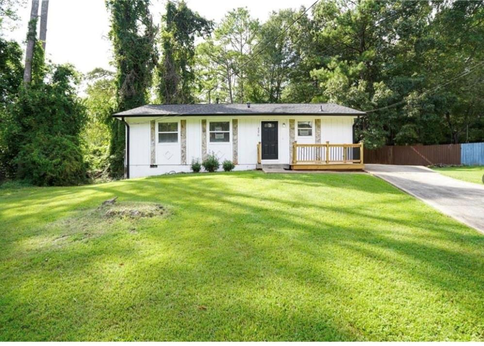 a view of a house with a big yard and large trees