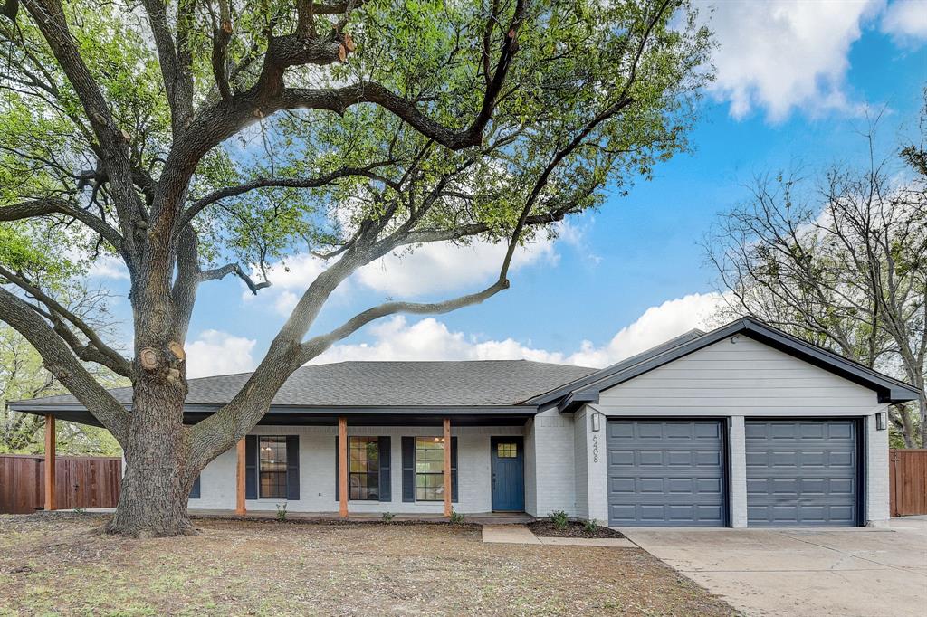 a front view of a house with a tree