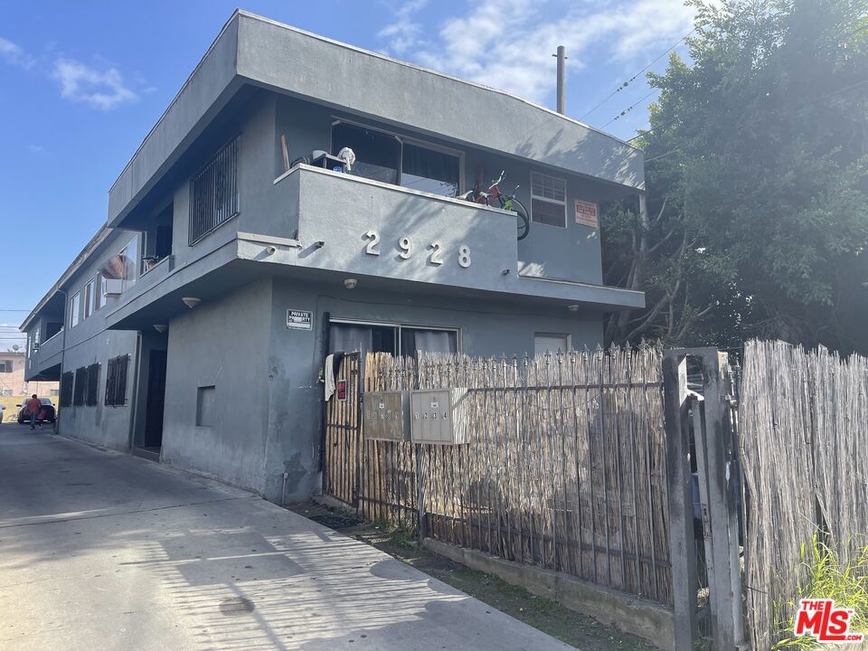 a view of a building with a small yard and large tree