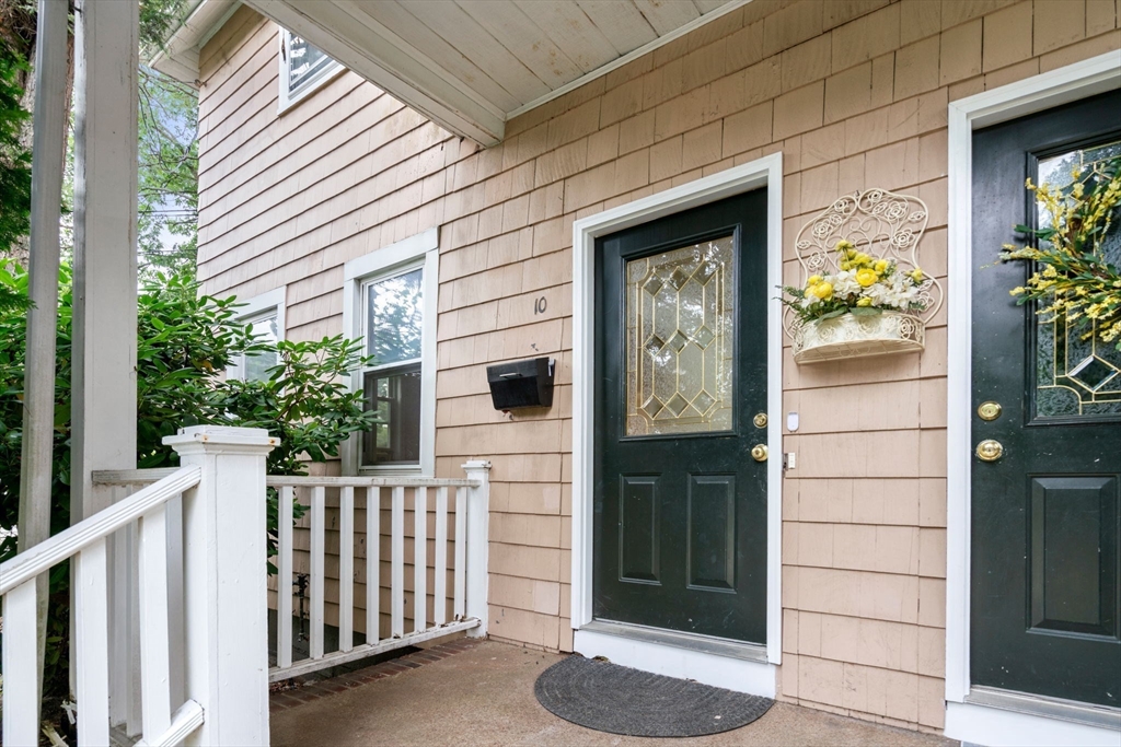 a view of a porch with a table and chair and front door