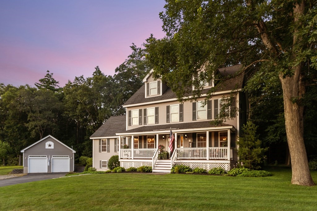 a front view of a house with a yard table and trees