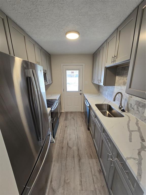 a kitchen with granite countertop a refrigerator and a sink