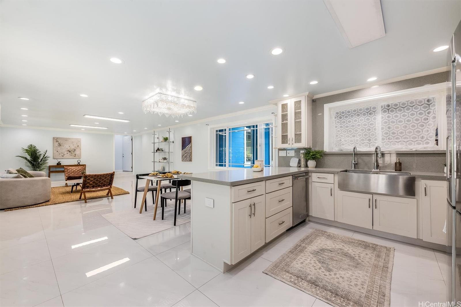 a large white kitchen with lots of white furniture and a dining table