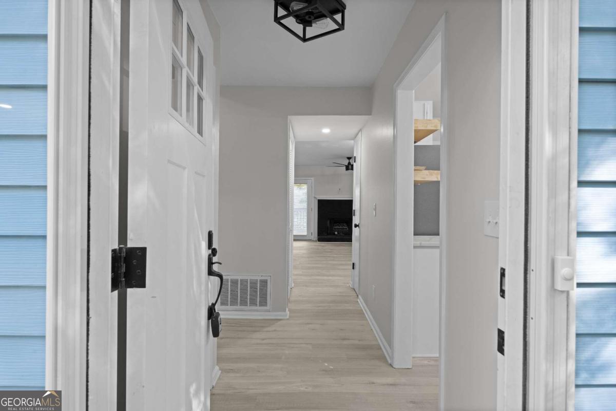 a view of a hallway with wooden floor and staircase