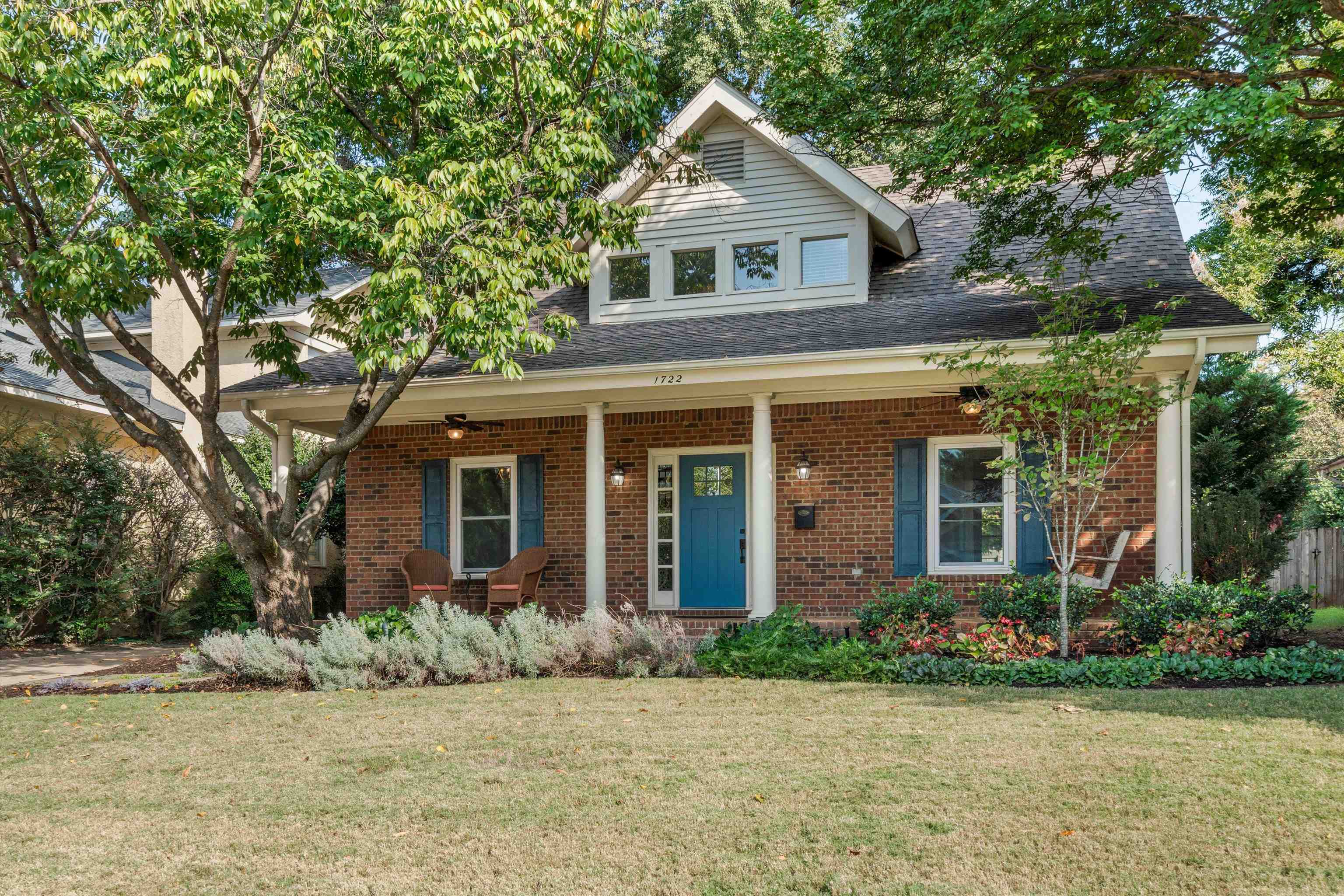 View of front of property featuring covered porch and a front yard