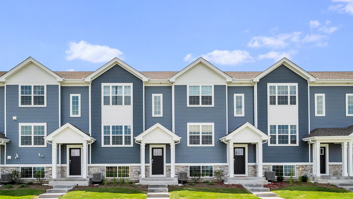 a front view of a residential houses with yard and green space