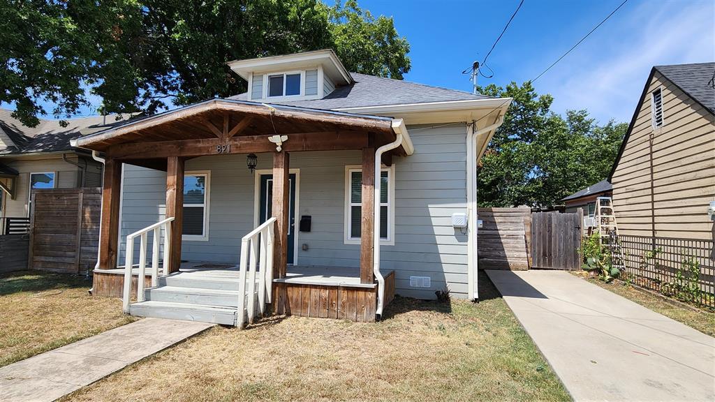 a view of a house with a small yard and wooden fence