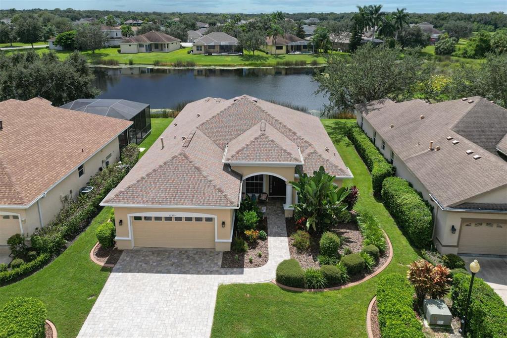 an aerial view of a house with a garden and lake view