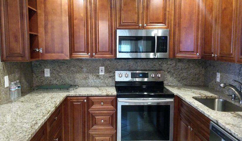 a kitchen with granite countertop a stove and a sink