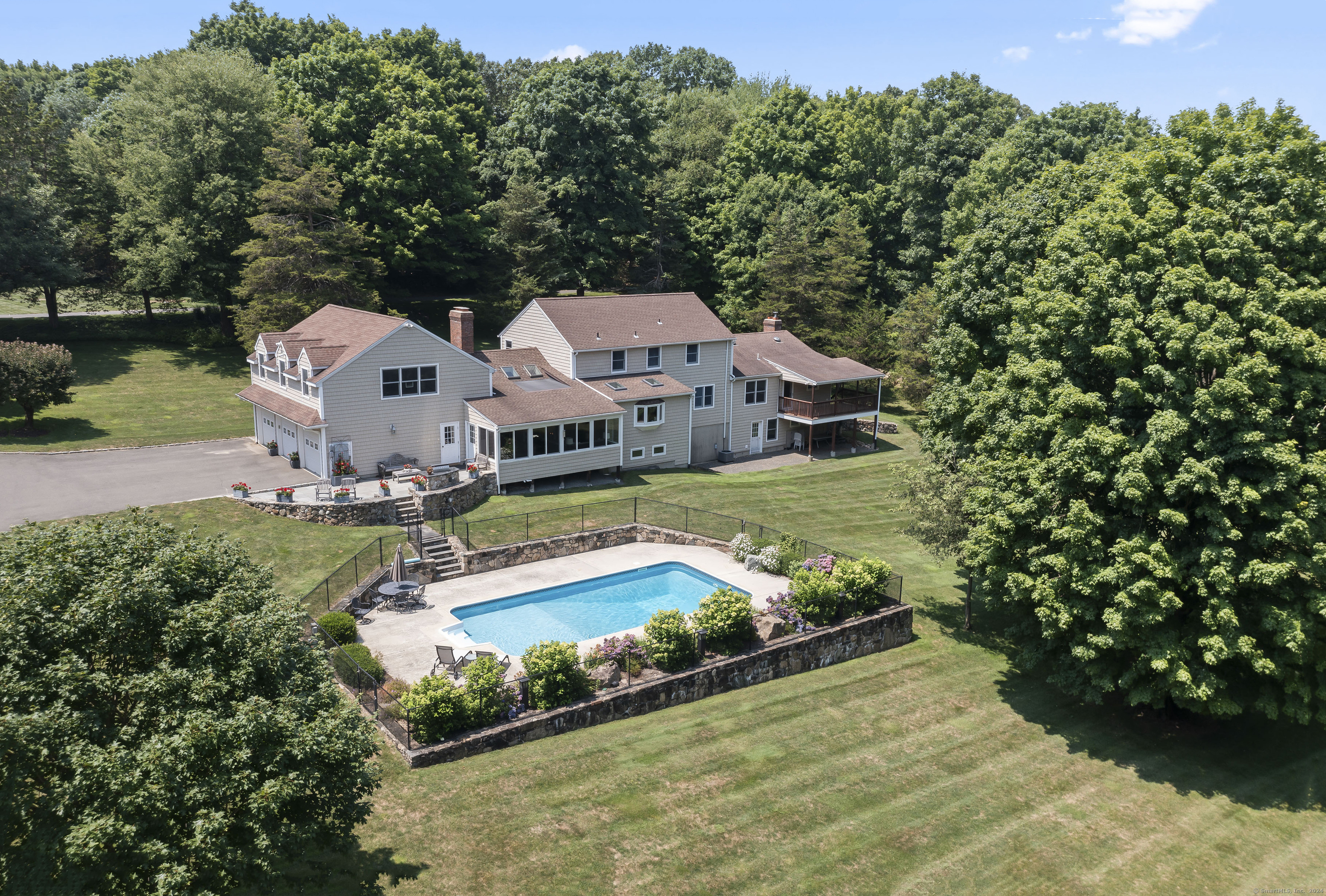 an aerial view of a house with swimming pool a yard and lake view