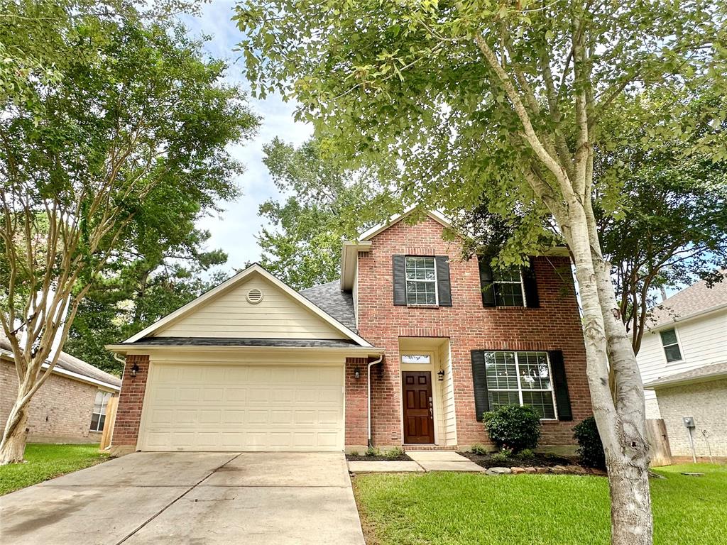 a front view of a house with a yard and trees