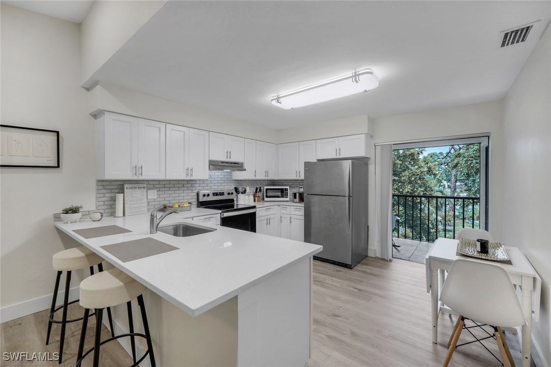 a kitchen with a table chairs refrigerator and microwave