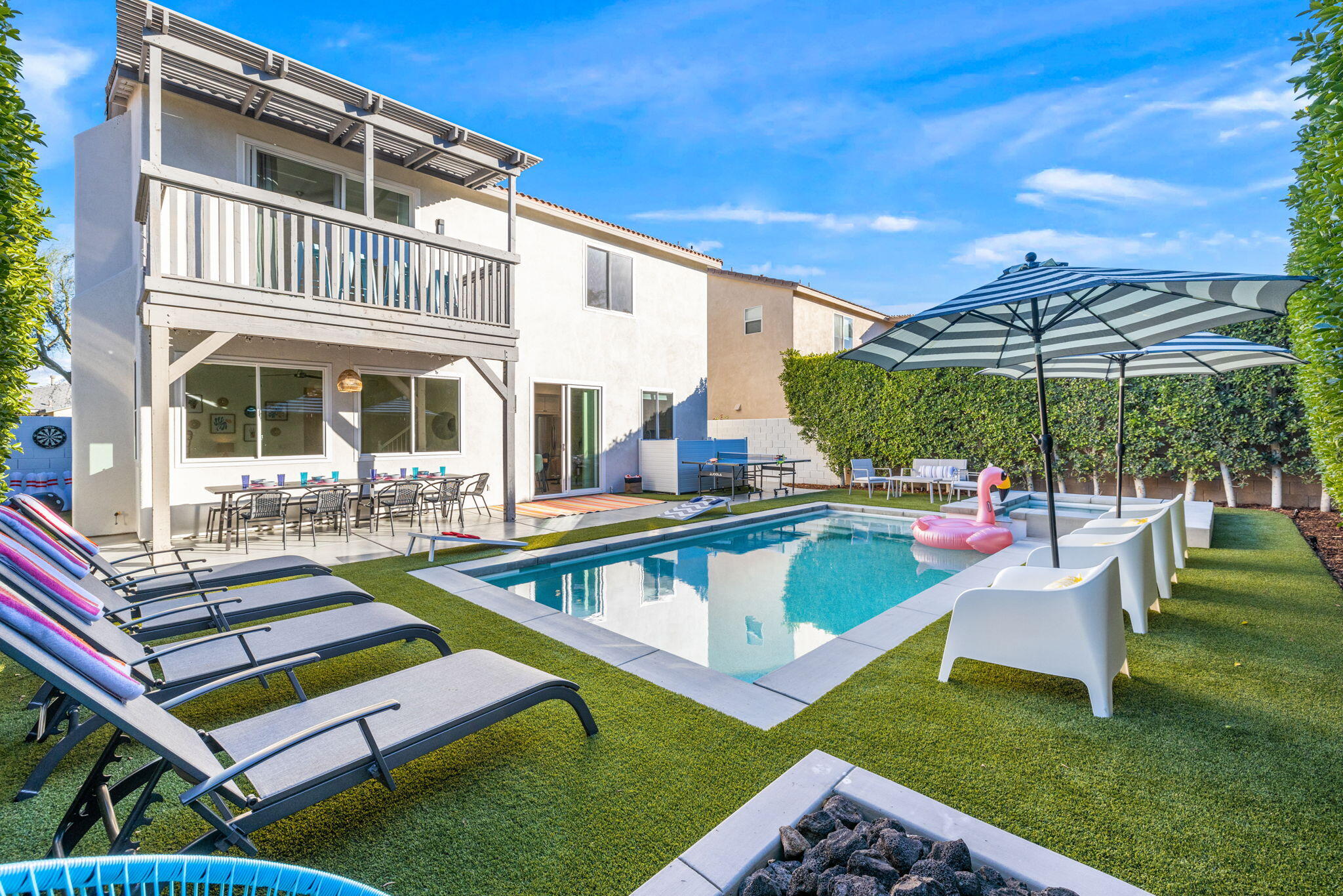 a view of a house with backyard swimming pool and sitting area