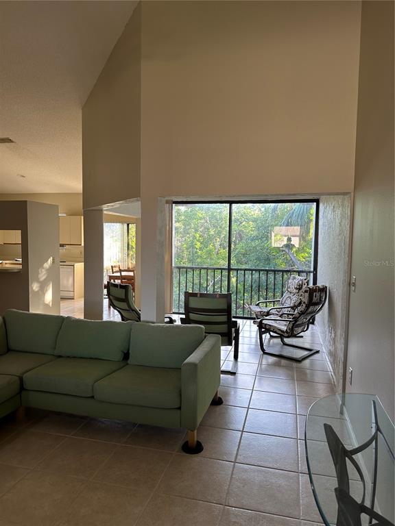 a living room with furniture and a floor to ceiling window