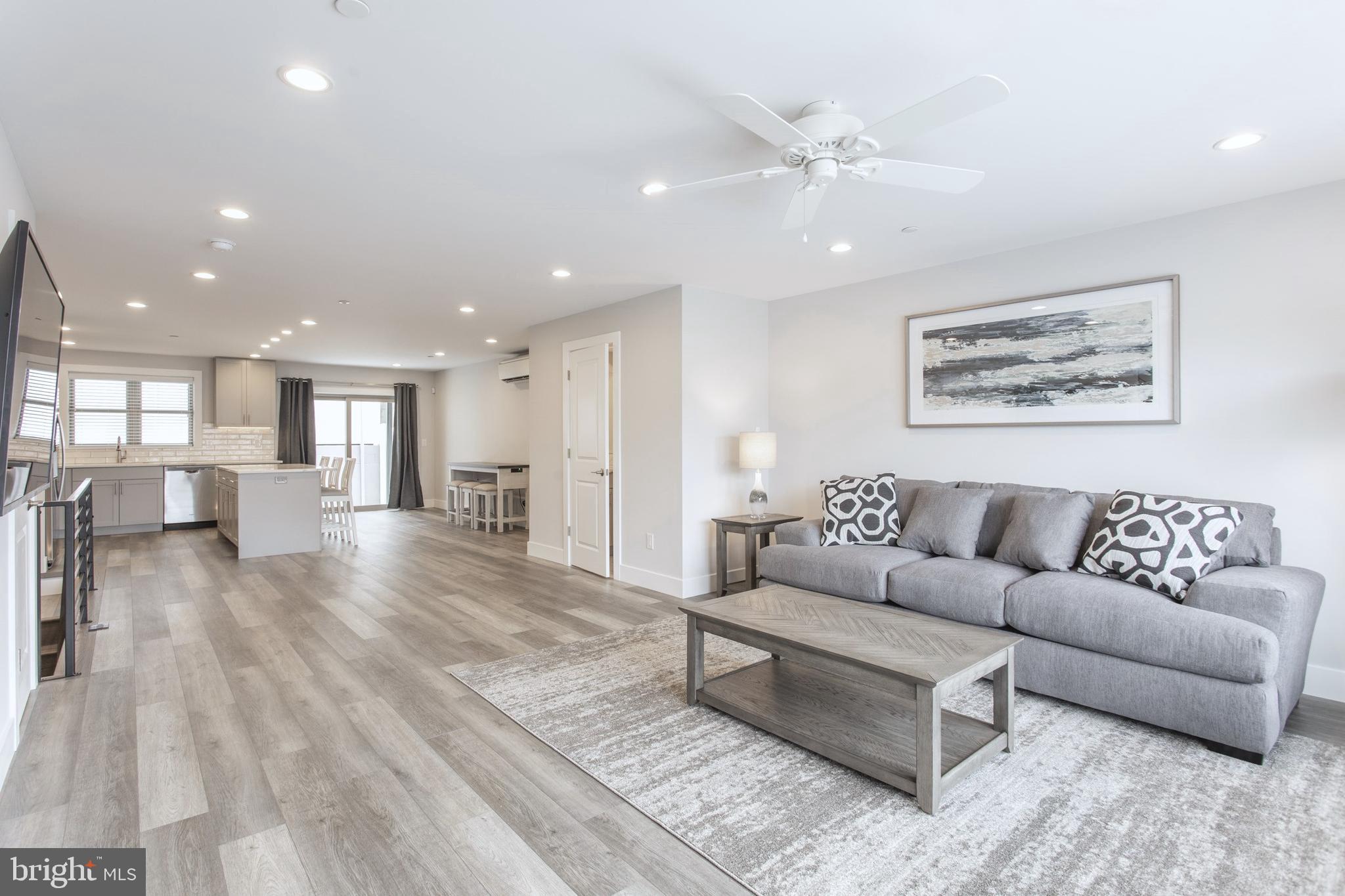 a living room with furniture and a view of kitchen