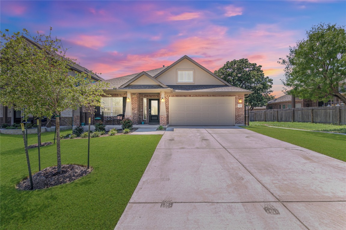 a front view of a house with a garden and yard