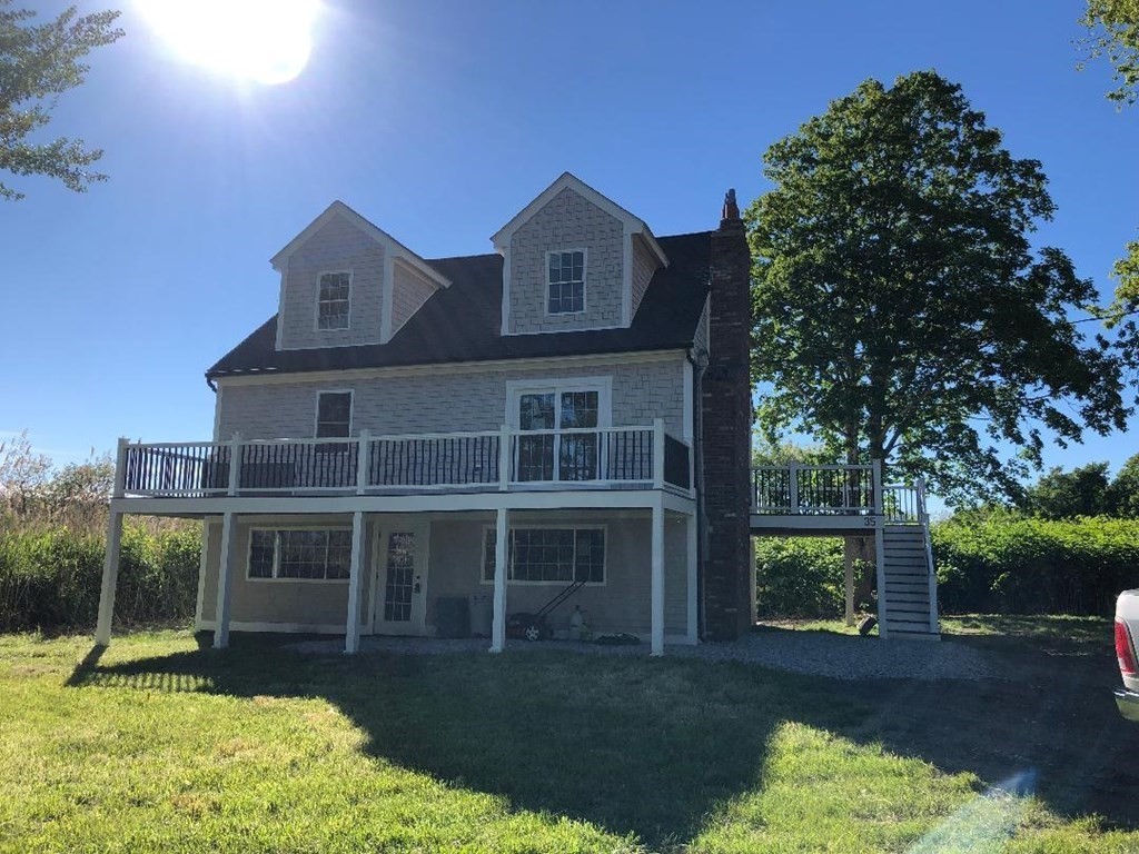 a view of a big yard in front of a house with a large tree