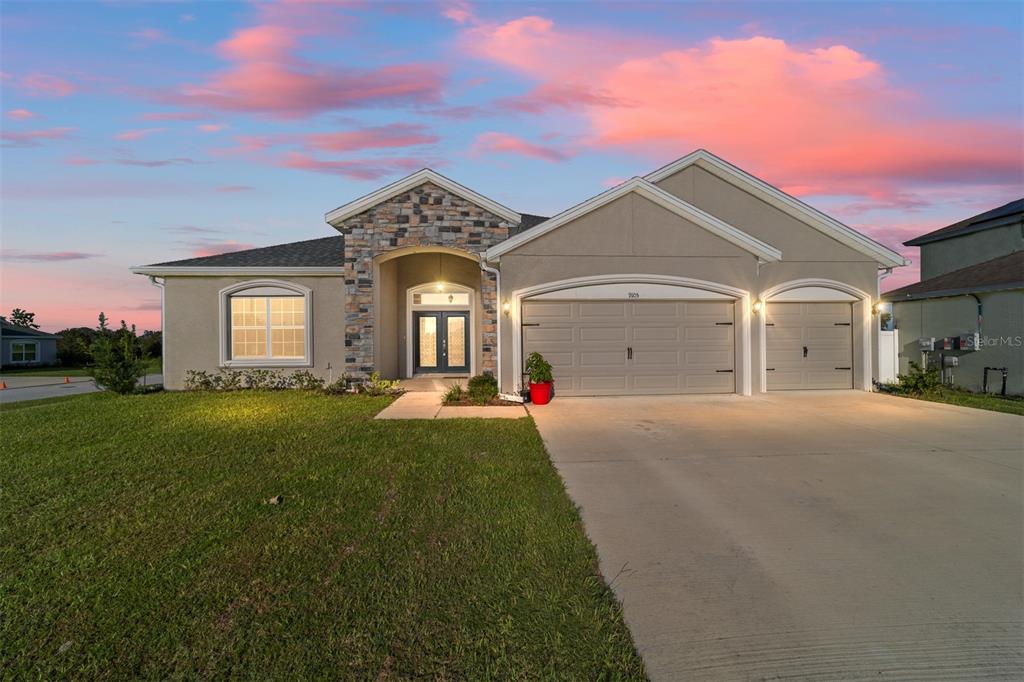 a front view of a house with a yard and garage