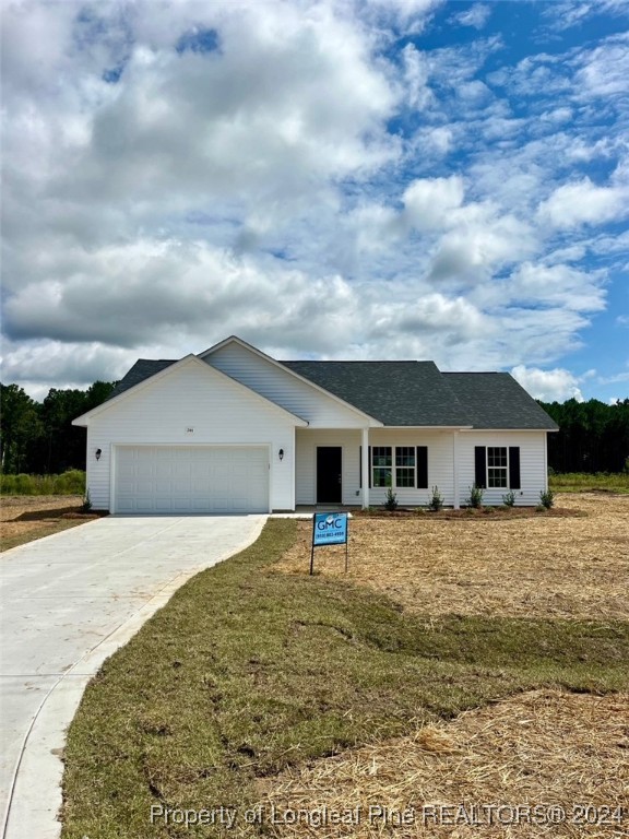 a front view of house with yard and trees in the background