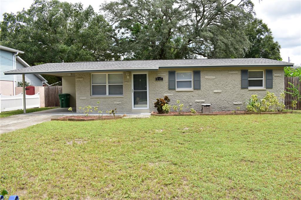 a front view of house with yard and trees around