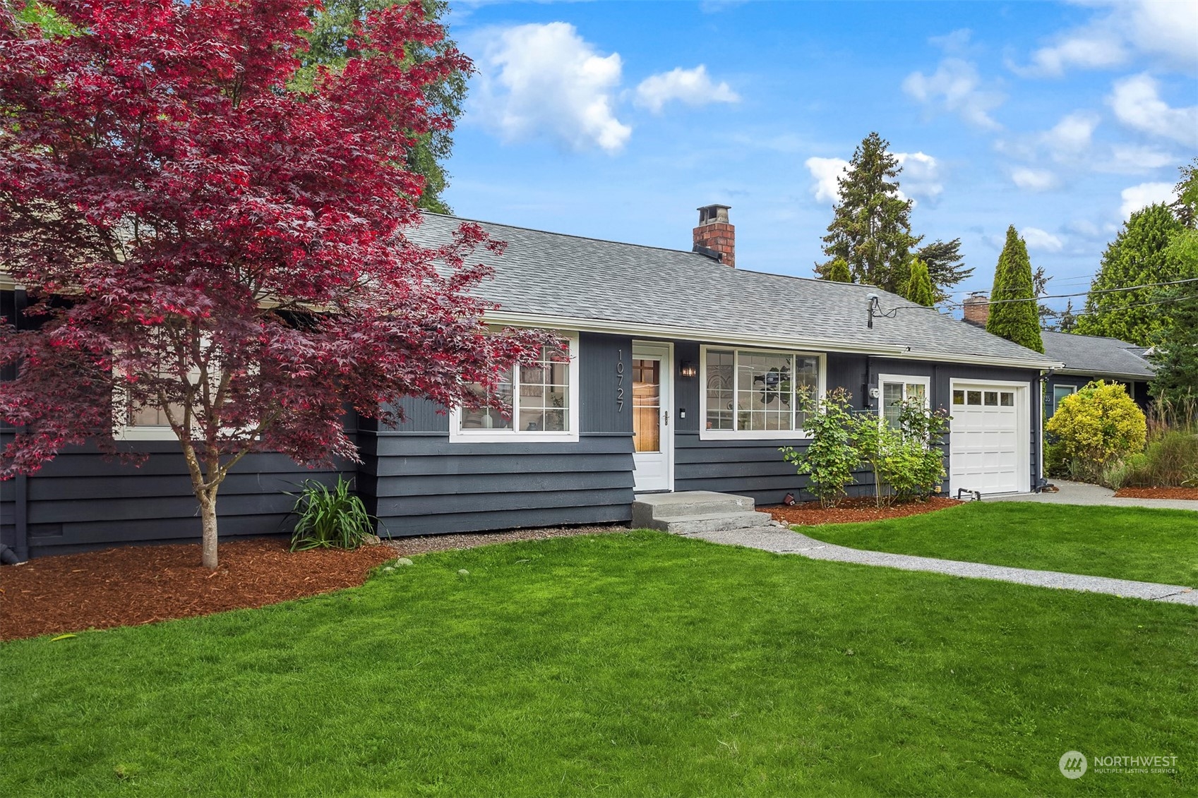 a front view of a house with a garden