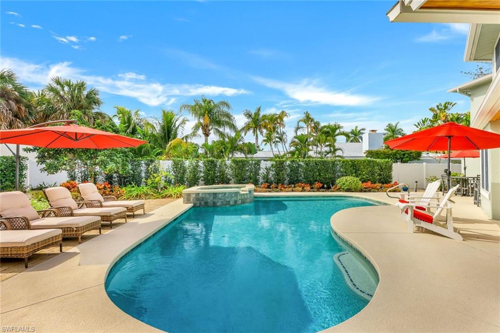 View of swimming pool with an in ground hot tub and a patio area