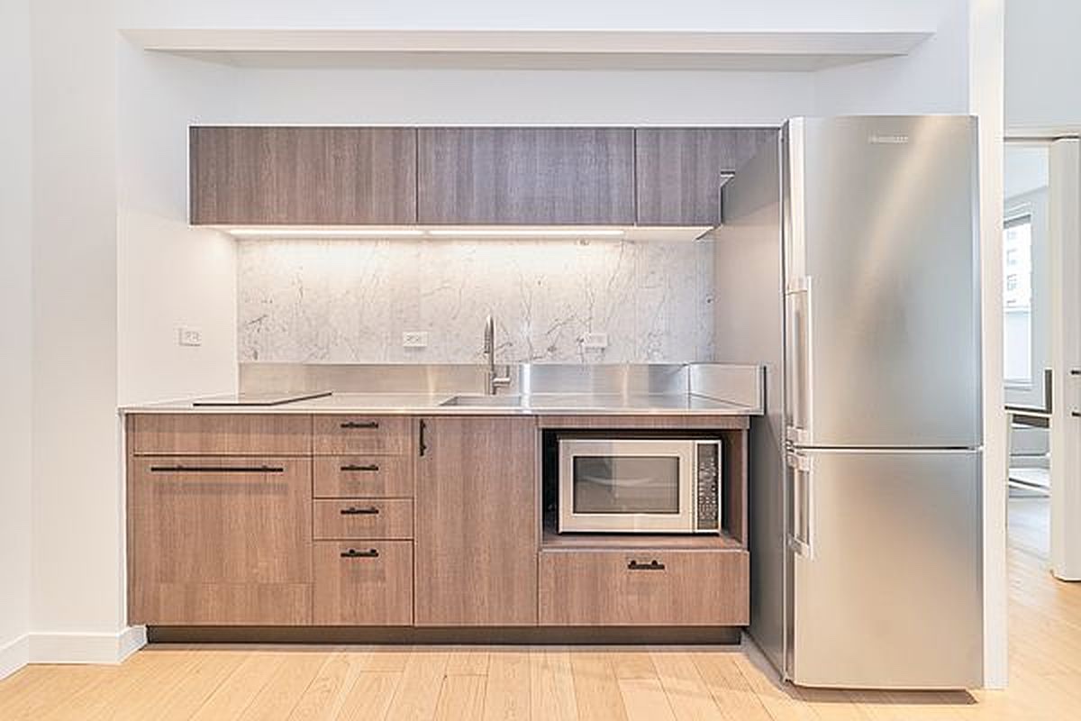 a kitchen with granite countertop a refrigerator and a sink