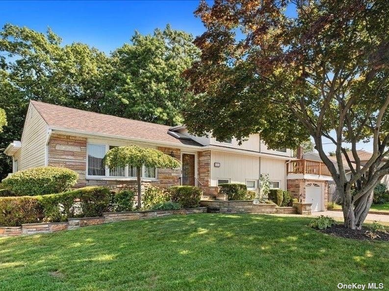 a backyard of a house with table and chairs plants and large tree