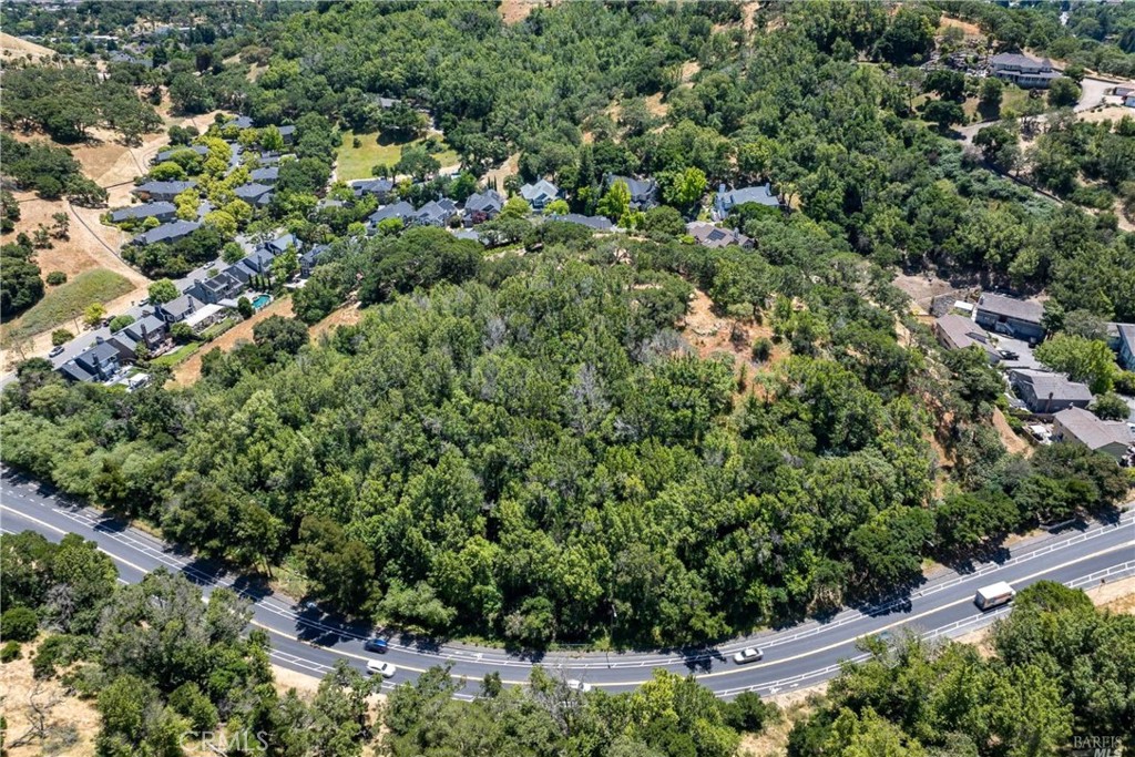 an aerial view of residential house with outdoor space and trees all around