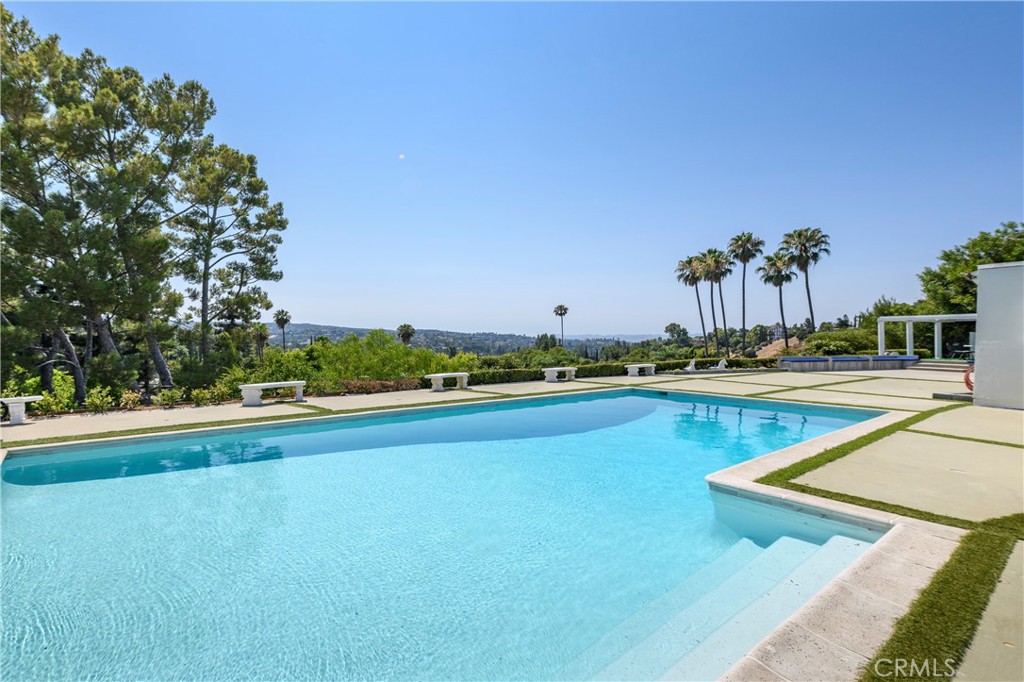 a view of swimming pool with outdoor seating and yard in back