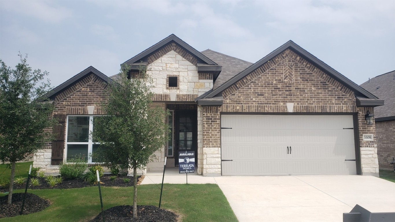 a front view of a house with a yard and garage