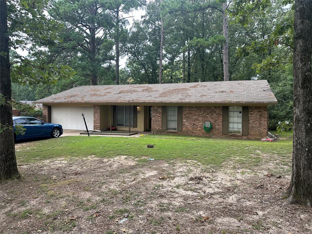 a view of a house with a yard and large tree