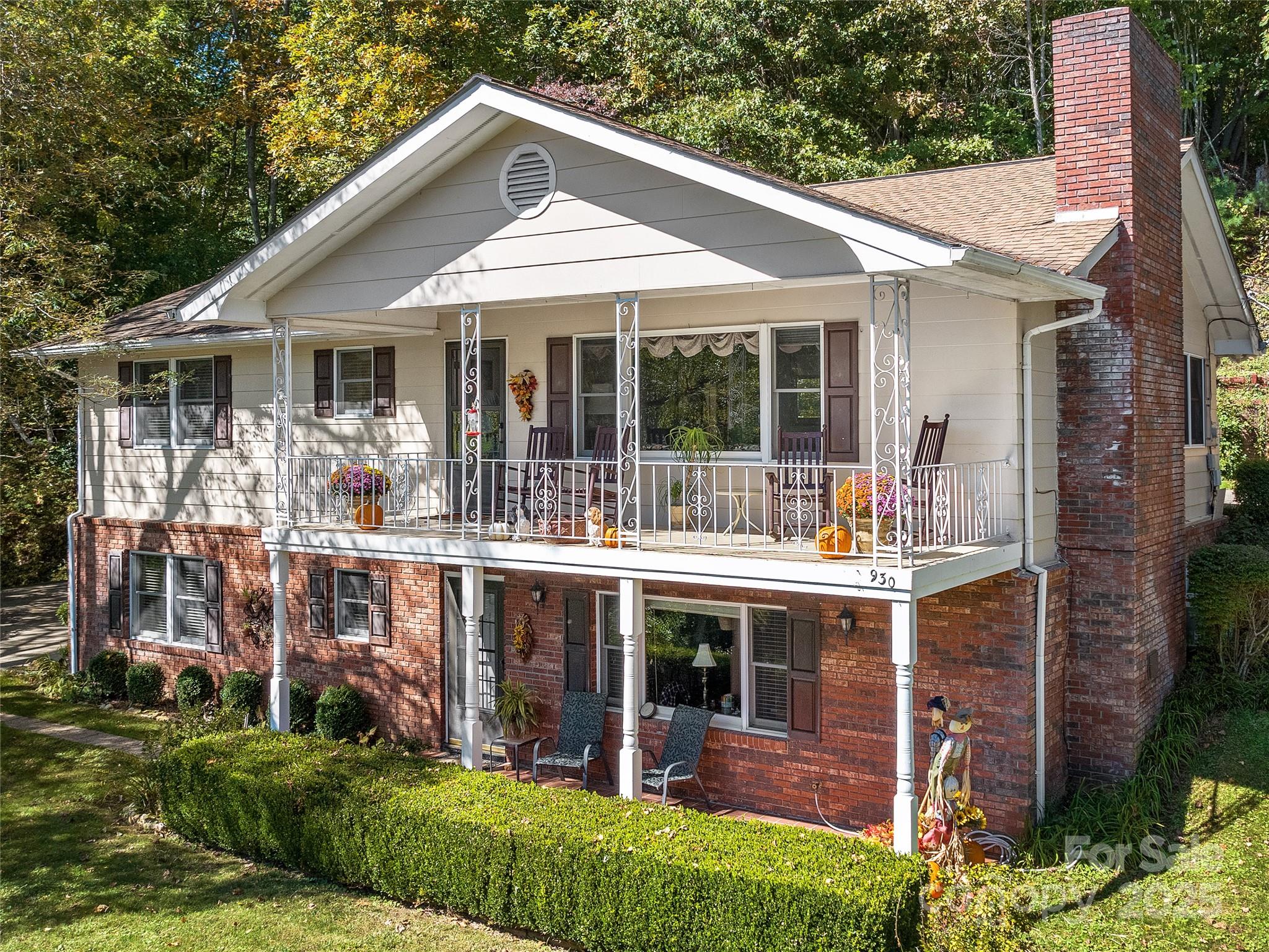 a front view of a house with a garden and balcony