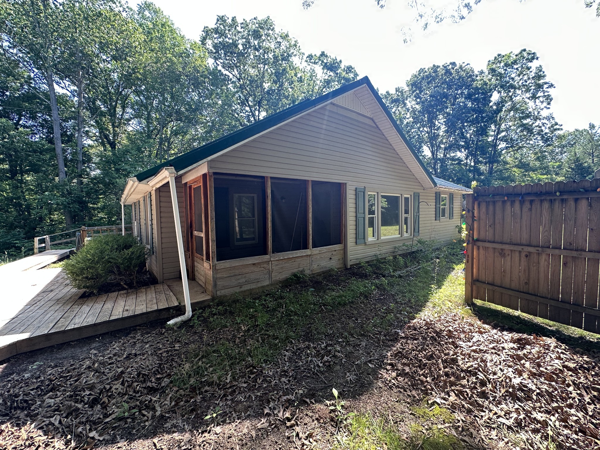 a backyard of a house with plants and wooden fence