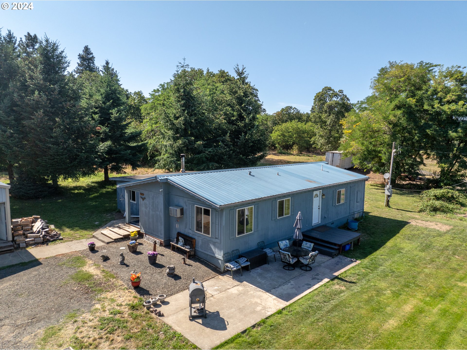 an aerial view of a house with yard patio and fire pit