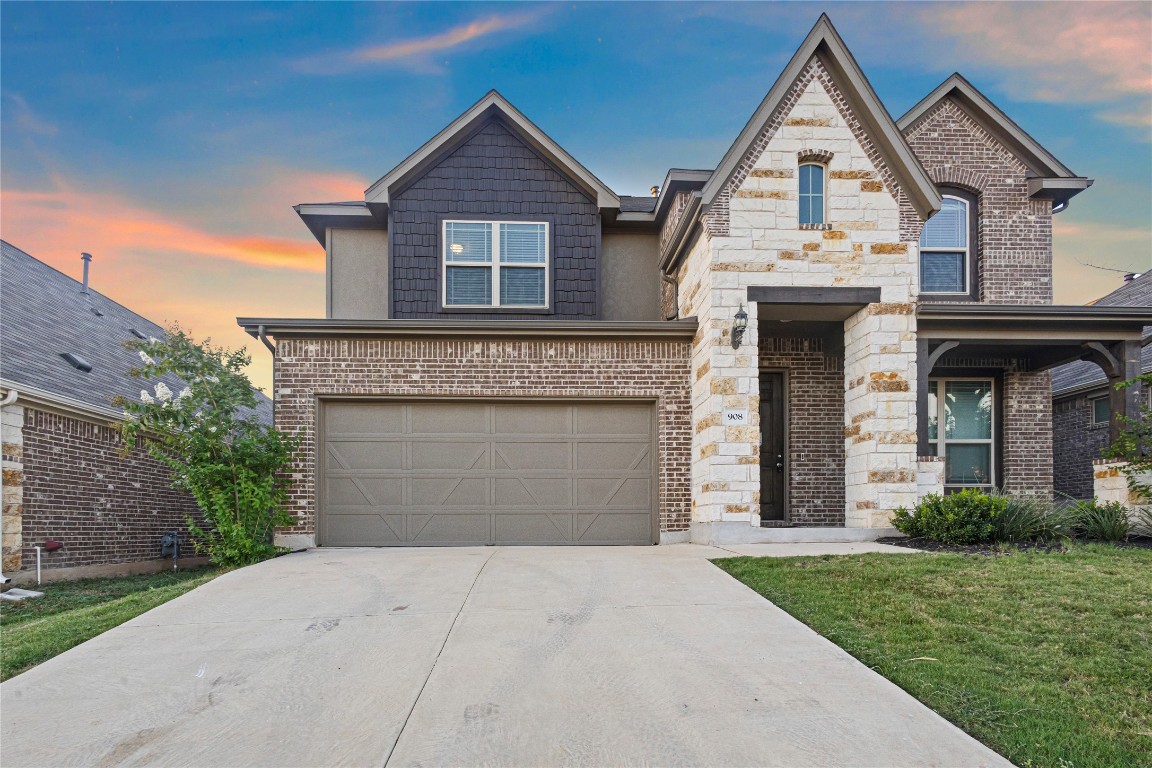 a front view of a house with a yard and garage