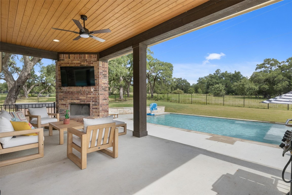 a view of a patio with couches table and chairs under an umbrella