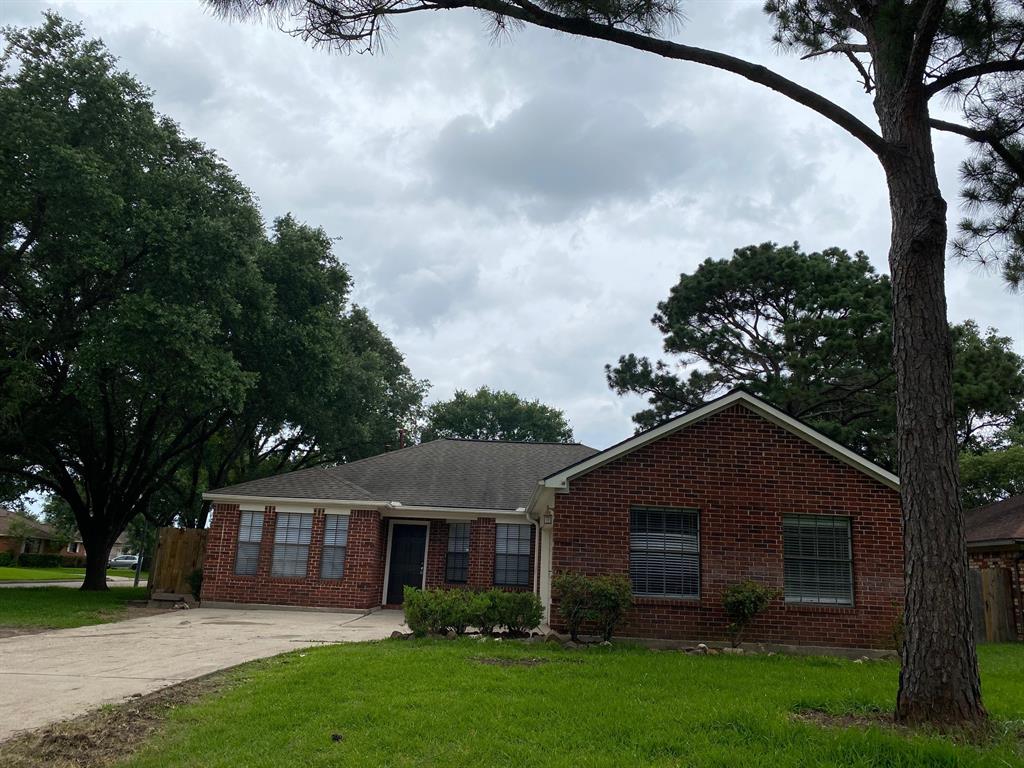 a view of house with yard entertaining space and a large tree