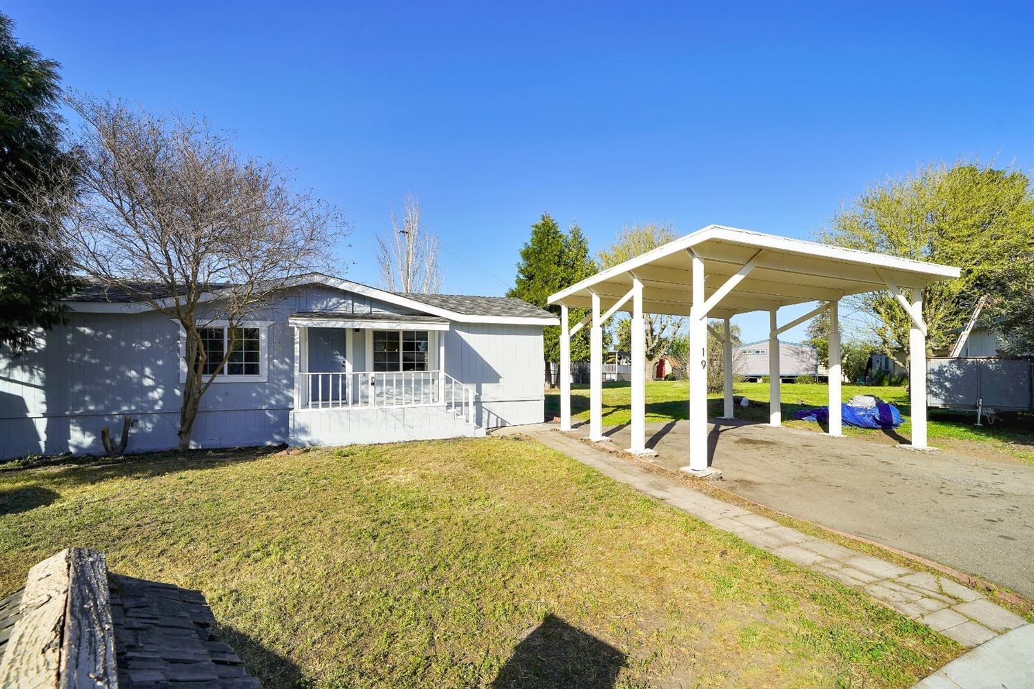 a view of a house with backyard and sitting area