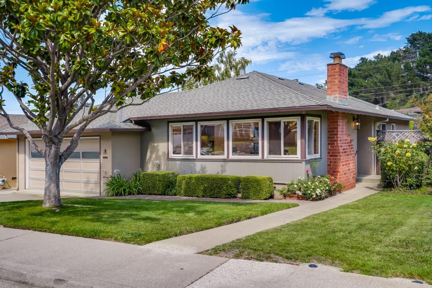 a front view of a house with a garden