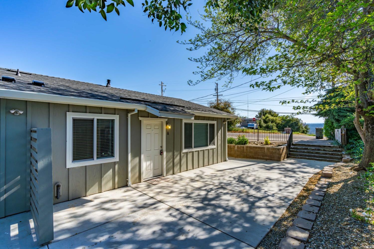 a view of a house with backyard and sitting area