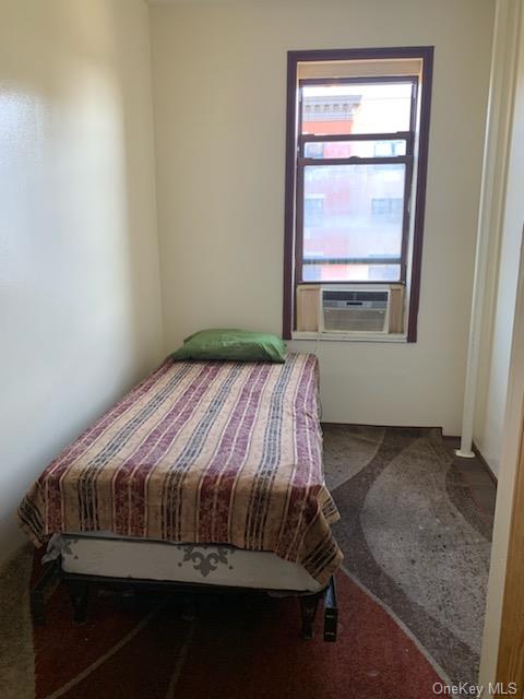 Bedroom featuring cooling unit and carpet flooring