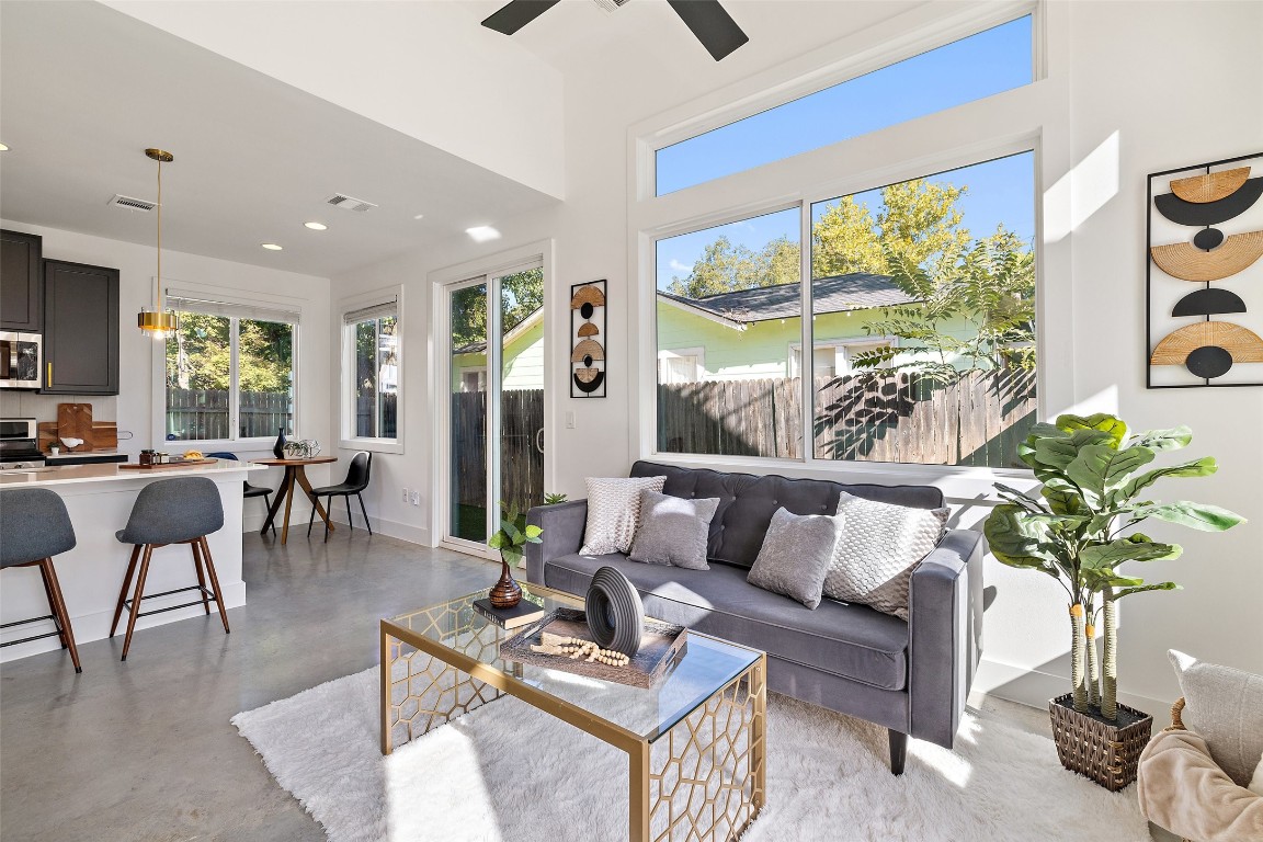 a living room with furniture potted plant and a large window