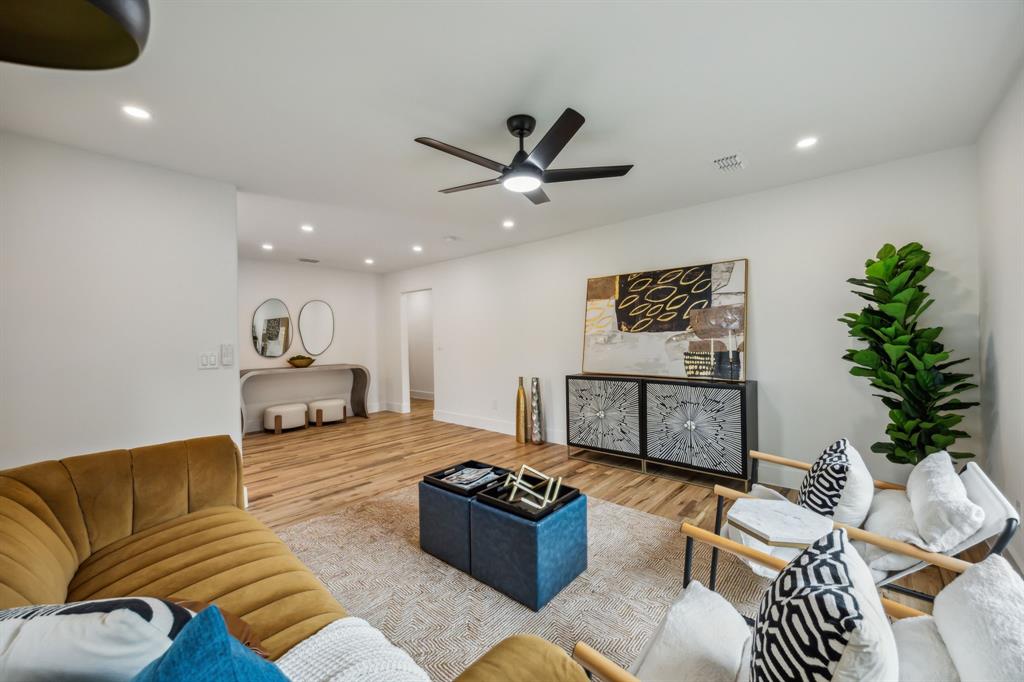 a living room with furniture ceiling fan and a potted plant