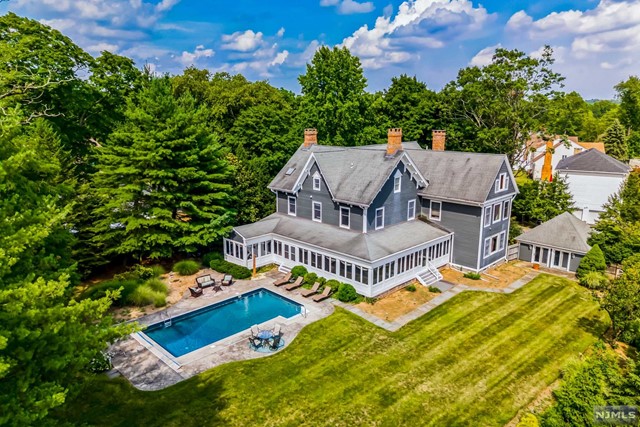 an aerial view of a house with swimming pool and big yard