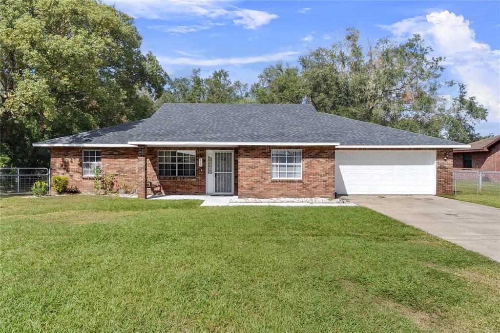 a front view of a house with a yard and trees