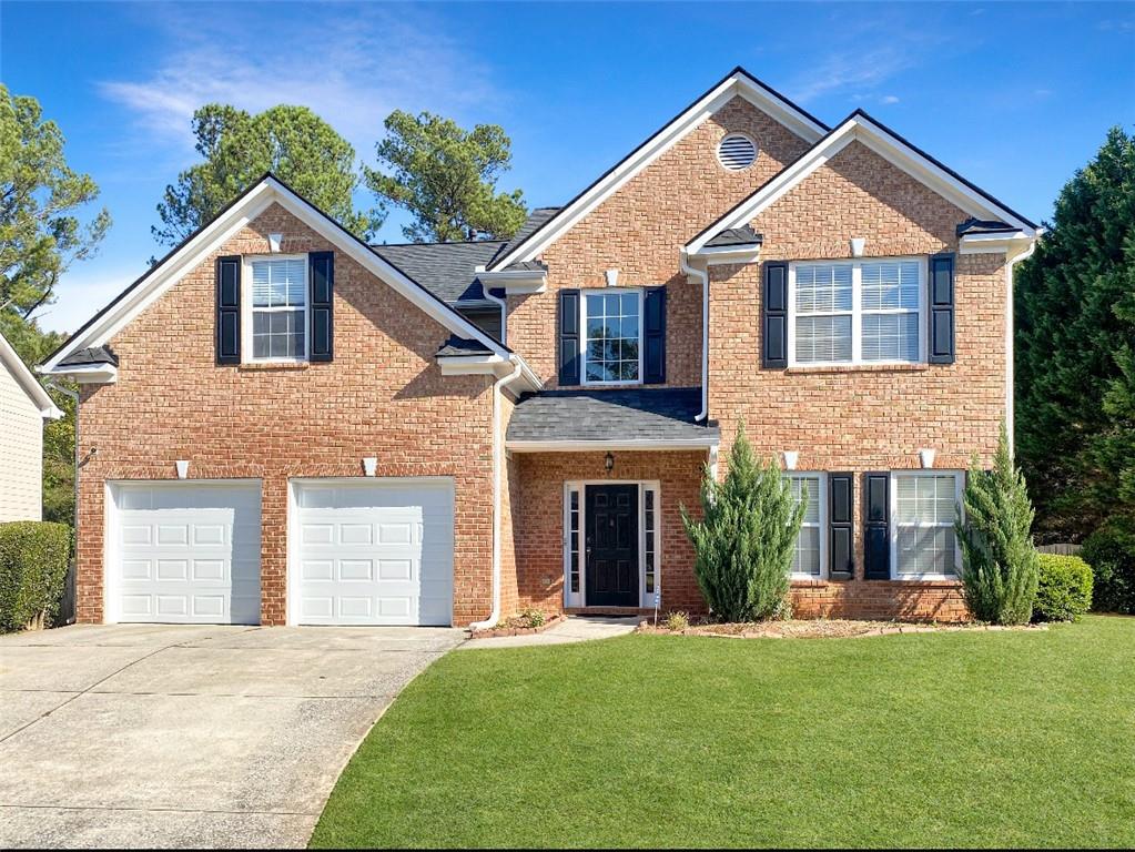 a front view of a house with a yard and garage