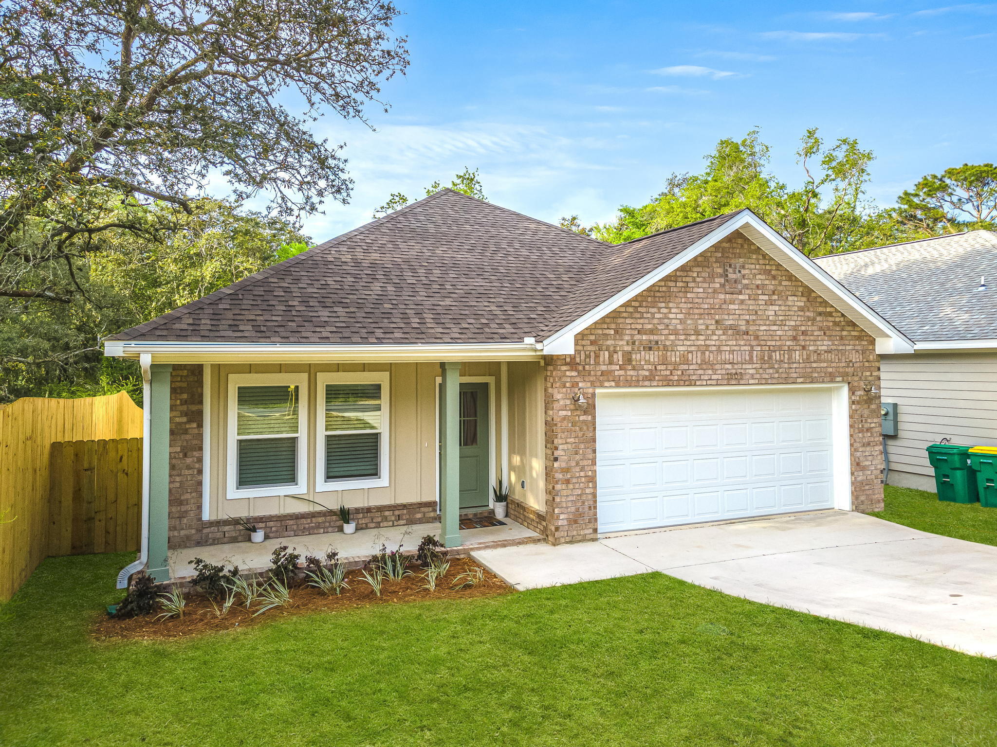 a front view of a house with a garden and yard