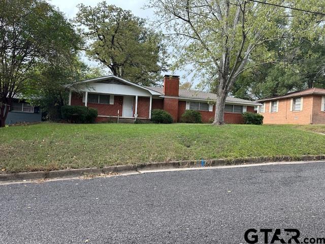 a front view of a house with a yard and trees