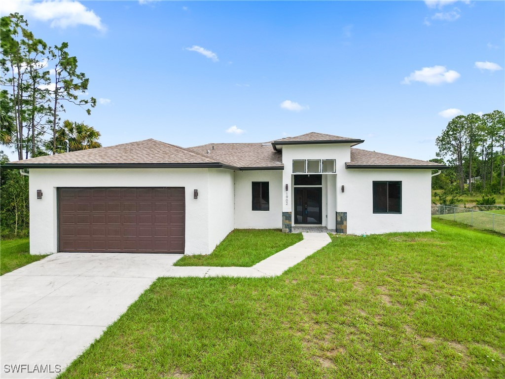 a front view of house with yard and garage